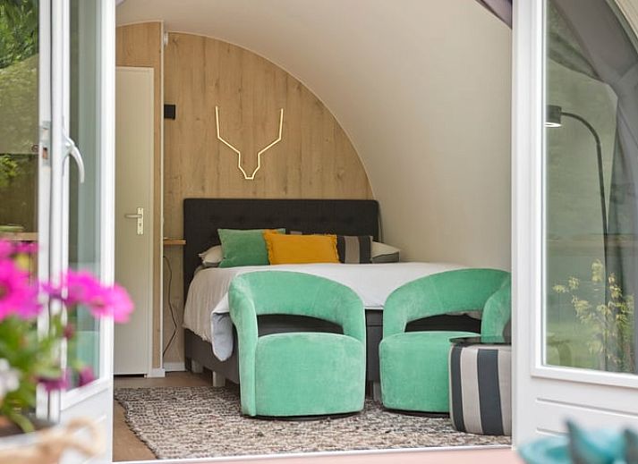 Vakantiehuisje in Rheden, Veluwe, Gelderland met charmante houten veranda omringd door groen.