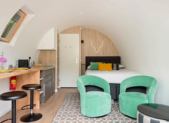 Vakantiehuisje in Rheden, Veluwe, Gelderland met charmante houten veranda omringd door groen.