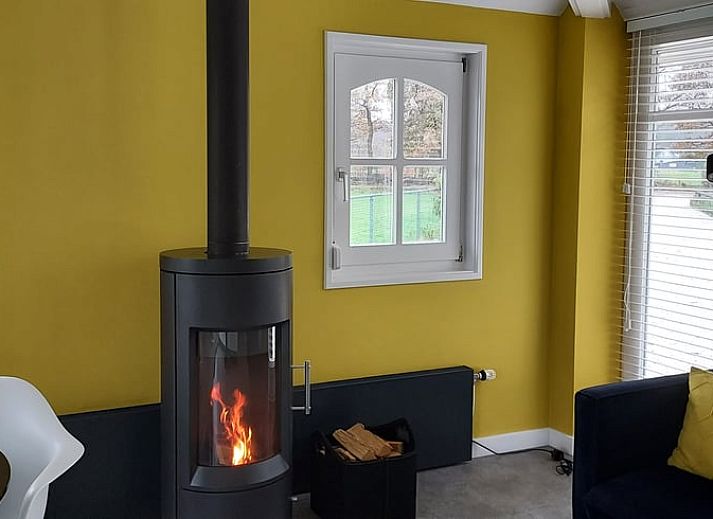 Rueckansicht des Ferienhauses in Heerde mit Terrasse und geschlossenem Garten in Gelderland.