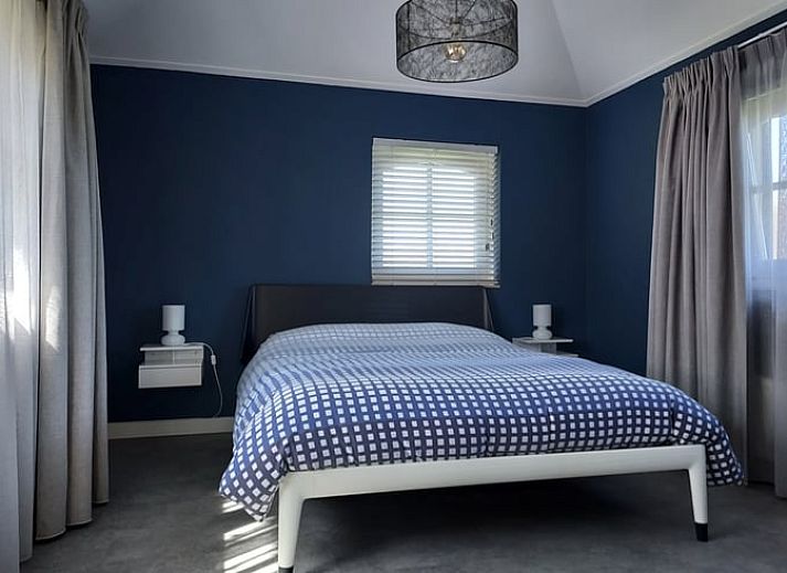 Rueckansicht des Ferienhauses in Heerde mit Terrasse und geschlossenem Garten in Gelderland.