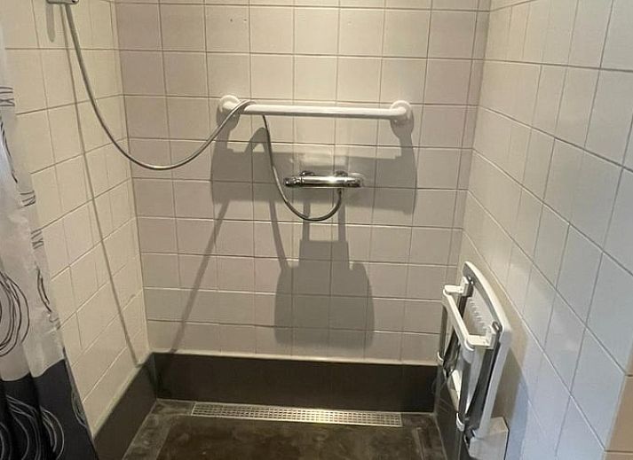 Geraeumige Terrasse am Ferienhaus in Wapenveld, Veluwe, Gelderland, umgeben von gruener Natur.