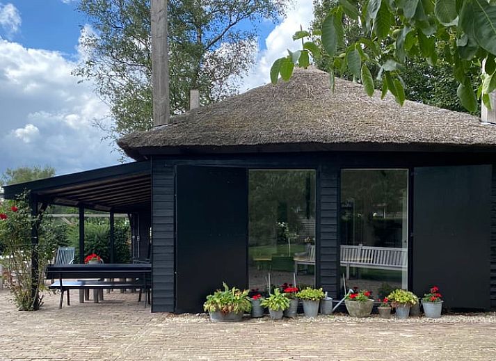 Cozy living room in Cottage in Wapenveld, a vacation home on the Veluwe in Gelderland with modern furnishings and comfortable seating area.