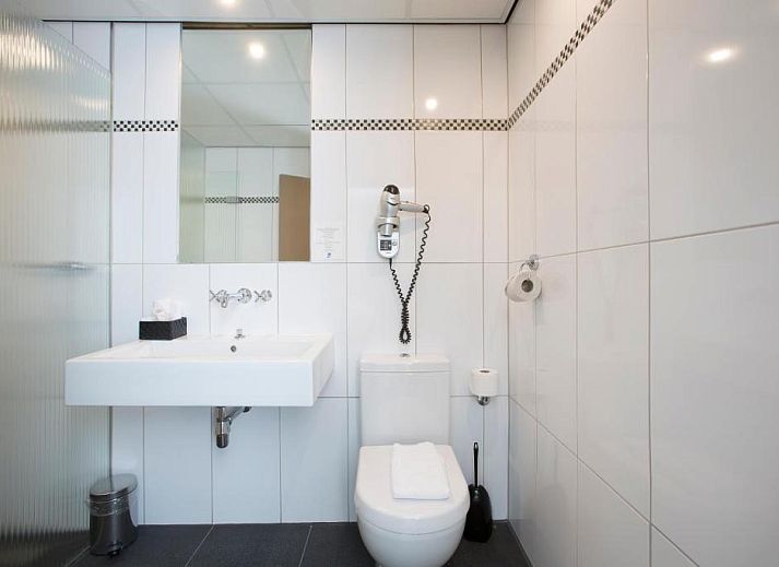 Ontvangstruimte Forest Hotel Den Helder, vakantie appartement met warme houten accenten en groene planten.