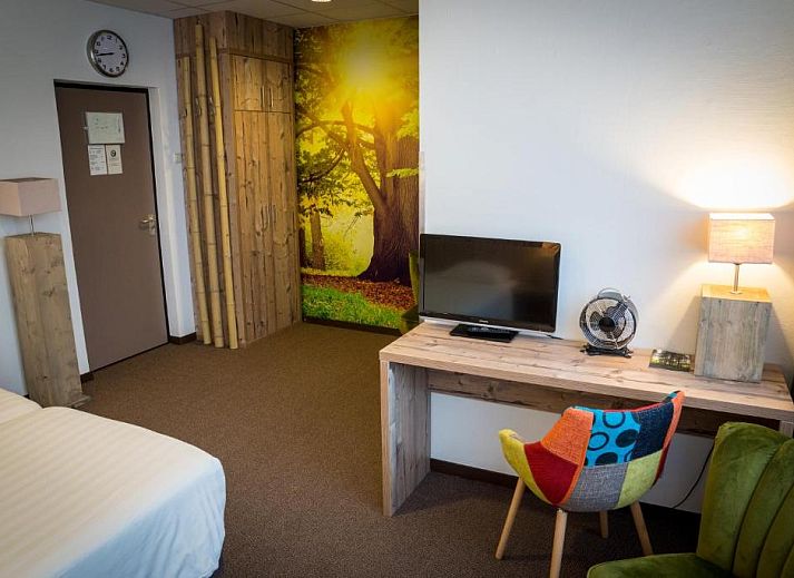 Ruime kamer in Forest Hotel Den Helder, vakantie appartement met kleurrijke accenten en natuurthema.