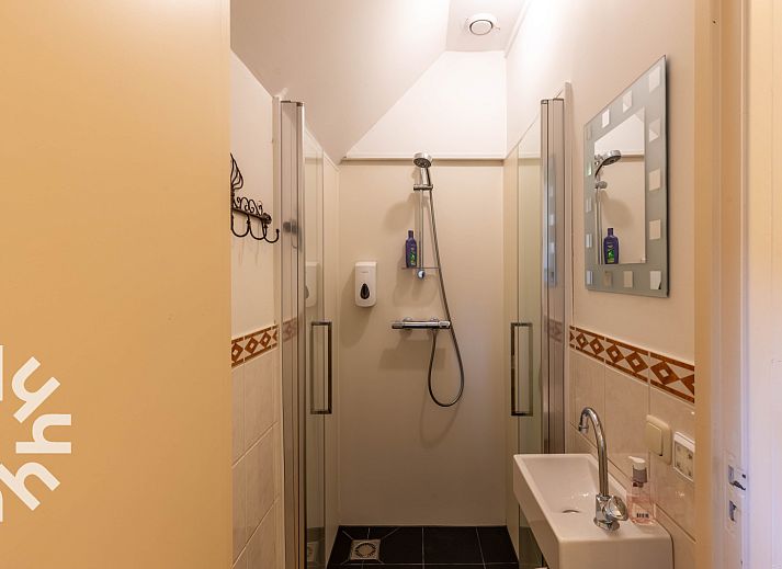 Attraktives Schlafzimmer im DG1763 Ferienhaus Loenen Veluwe mit Holzbalken und gemuetlicher Sitzecke.