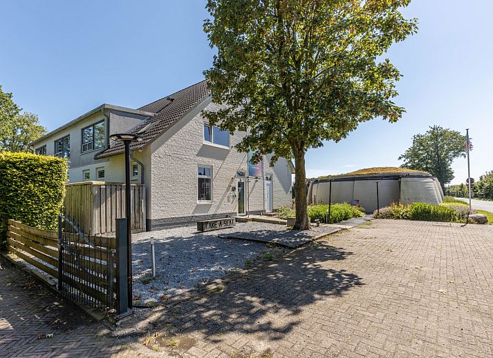 Stylish dining room in vacation home DG2126, Teuge, Veluwe, Gelderland, with wooden table, colorful flowers, and inspiring wall decor.