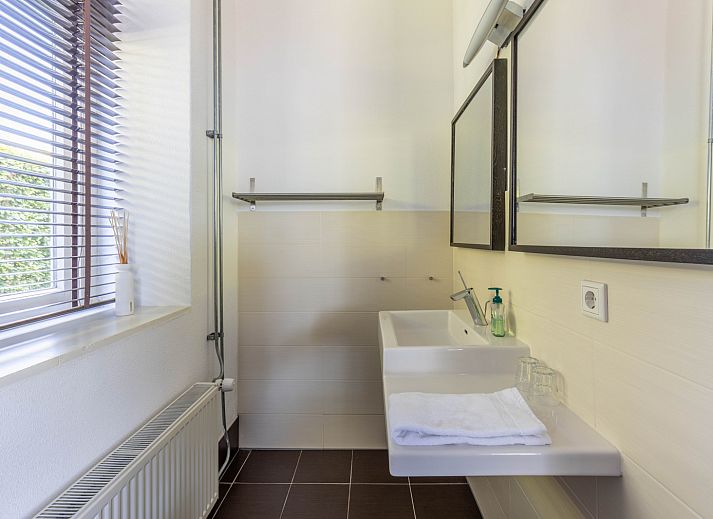 Stylish dining room in vacation home DG2126, Teuge, Veluwe, Gelderland, with wooden table, colorful flowers, and inspiring wall decor.