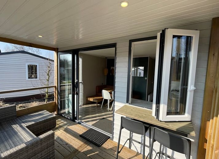 Veranda des Ferienhauses in Lieren, Veluwe, Gelderland mit Blick auf den gruenen Garten.