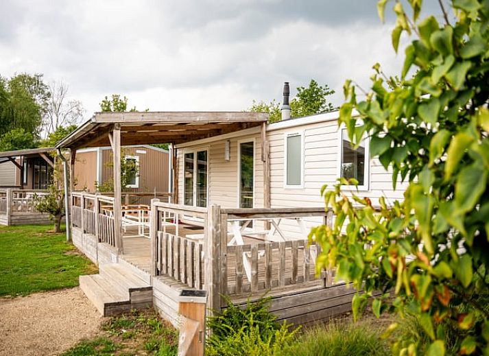 Ferienhaus in Lieren an der Veluwe mit Holzveranda und Blick auf die gruene Umgebung in Gelderland.