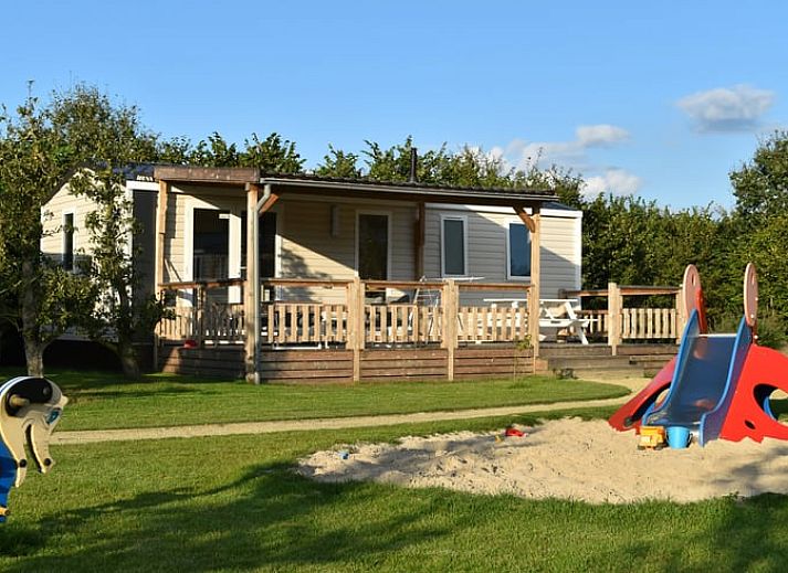 Ferienhaus in Lieren an der Veluwe mit Holzveranda und Blick auf die gruene Umgebung in Gelderland.