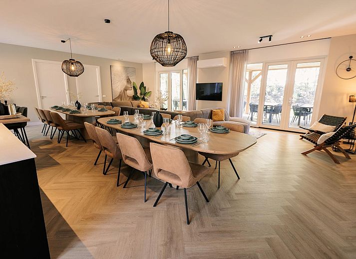 Zonovergoten gevel van Heide Villa, vakantiehuis in Wekerom, Veluwe, omgeven door natuur.