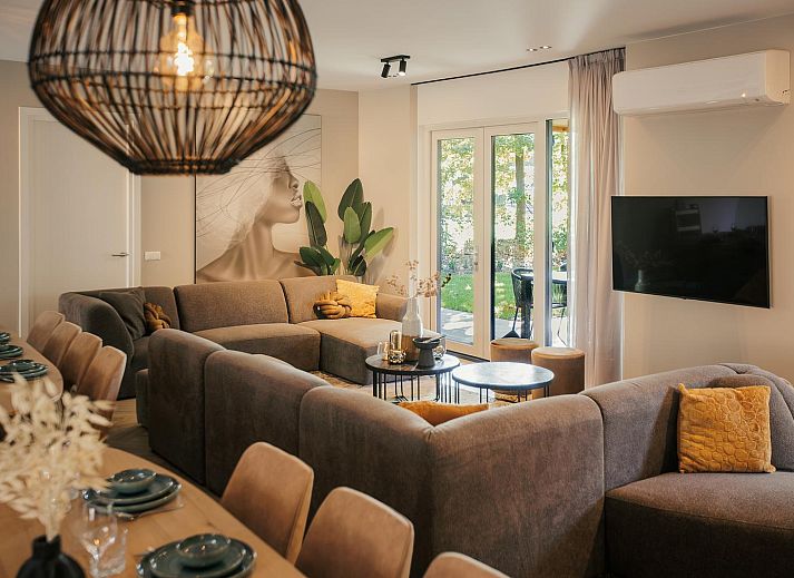 Zonovergoten gevel van Heide Villa, vakantiehuis in Wekerom, Veluwe, omgeven door natuur.