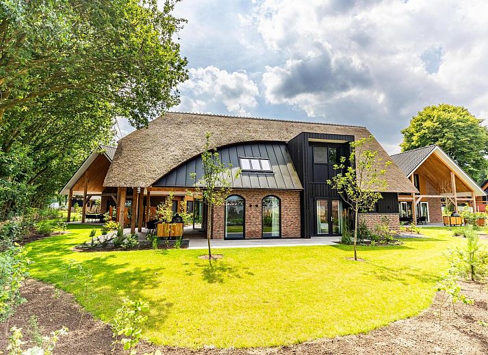 Voorzijde van Boerderij Villa met Binnenzwembad & Wellness in Wekerom, omgeven door groene natuur.