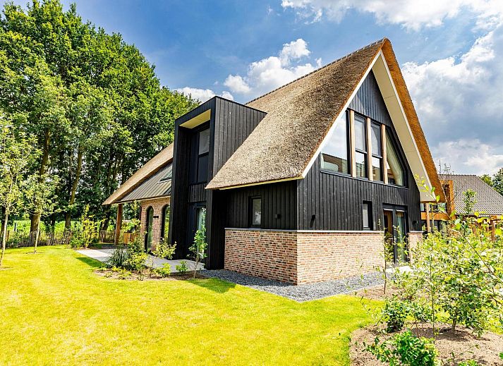 Voorzijde van Boerderij Villa met Binnenzwembad & Wellness in Wekerom, omgeven door groene natuur.