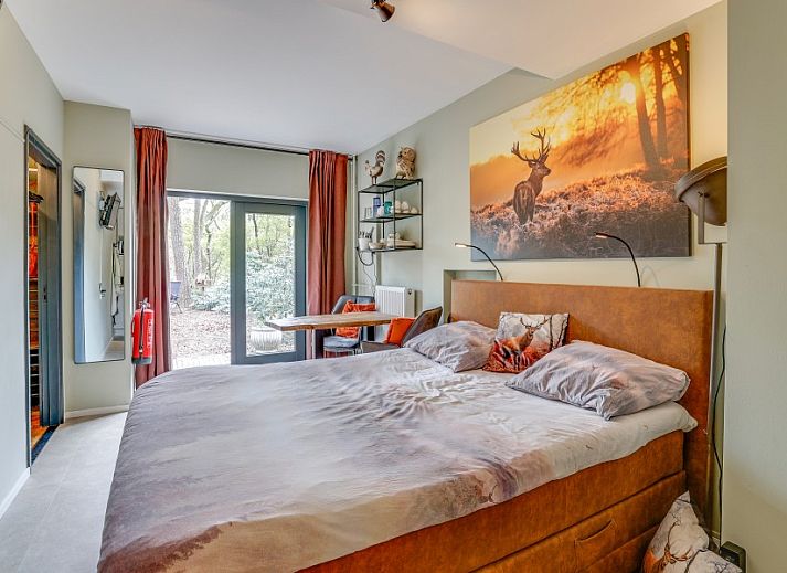 Attraktives Schlafzimmer des Studios REE in Wekerom, Veluwe, Gelderland mit Blick auf ein bewaldetes Gebiet.