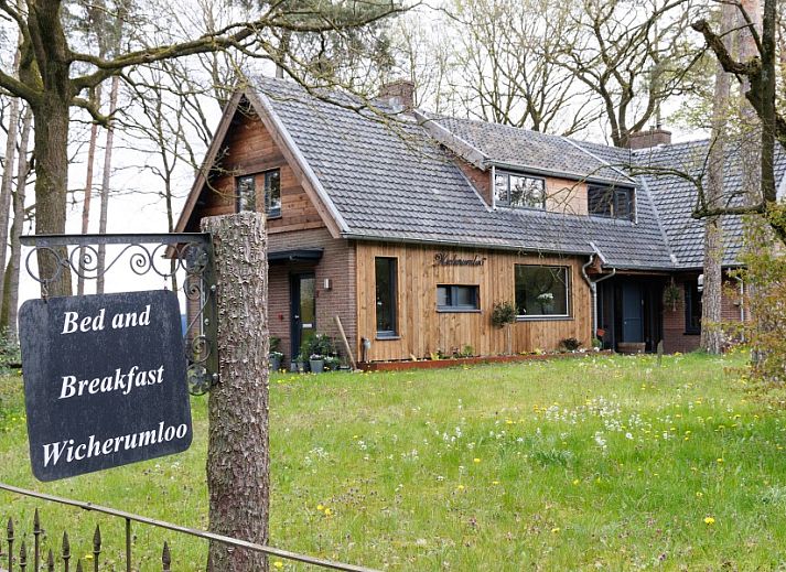 Charmanter Eingang zum Studio REE, Bed and Breakfast in Wekerom, Veluwe mit Gruenpflanzen und Backsteinmauer.