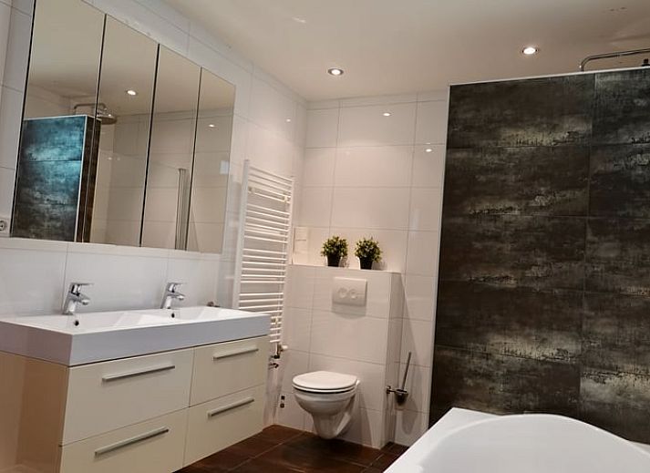 Ingang van vakantiehuisje in Bennekom met bloeiende rododendrons, perfect voor een Veluwe vakantie.