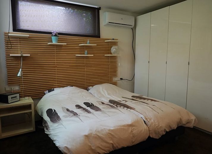 Ingang van vakantiehuisje in Bennekom met bloeiende rododendrons, perfect voor een Veluwe vakantie.