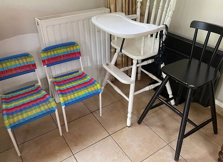 Tuin van vakantiehuisje in Bennekom met ligstoelen en kleurrijke bloemen, midden in de Veluwe.