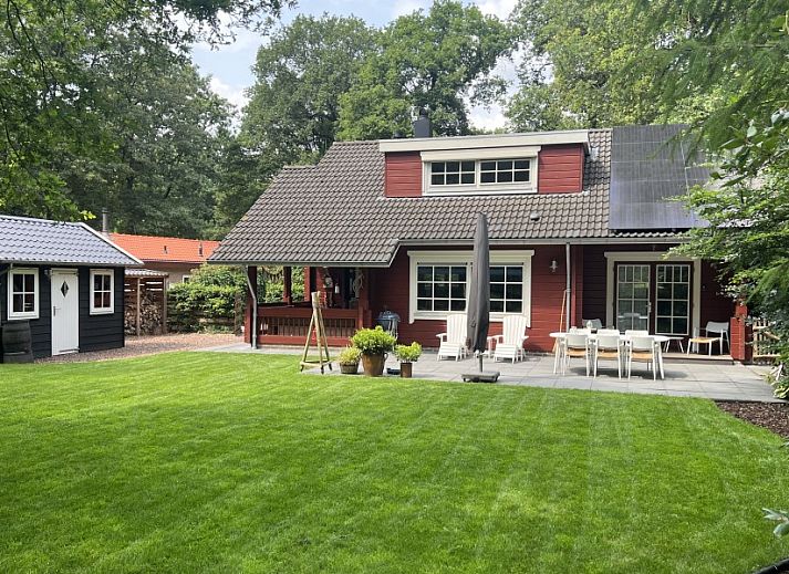 Boshuis Denne in Bennekom, Veluwe, Gelderland surrounded by green nature and colorful flowers at vacation home.