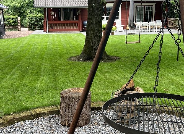 Boshuis Denne in Bennekom, Veluwe, Gelderland surrounded by green nature and colorful flowers at vacation home.