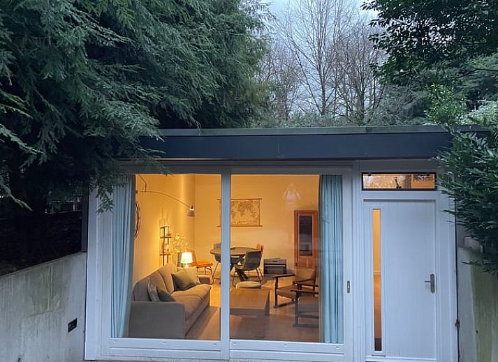 Ontspan in de groene tuin van Huisje in Bennekom, een vakantiehuis op de Veluwe, Gelderland met een prive hot tub en natuurlijke omgeving.