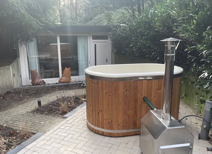 Ontspan in de groene tuin van Huisje in Bennekom, een vakantiehuis op de Veluwe, Gelderland met een prive hot tub en natuurlijke omgeving.