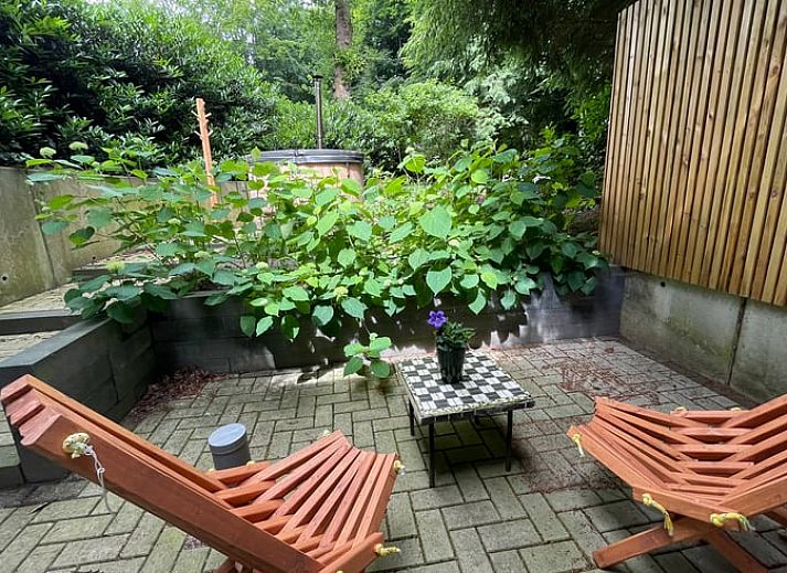 Geniet van ontspanning bij het Huisje in Bennekom, Veluwe, met een luxe hot tub op het terras omringd door groene natuur.