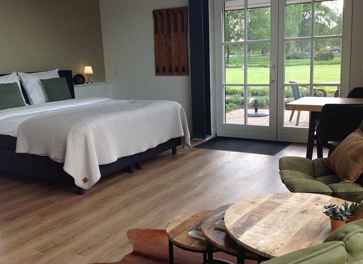 Vakantiehuisje in Eerbeek op de Veluwe, Gelderland, omgeven door kleurrijke bloemen en weidse natuur voor een ontspannen verblijf.