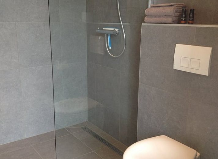 Vakantiehuisje in Eerbeek op de Veluwe, Gelderland, omgeven door een uitgestrekt groen veld en rustieke charme.