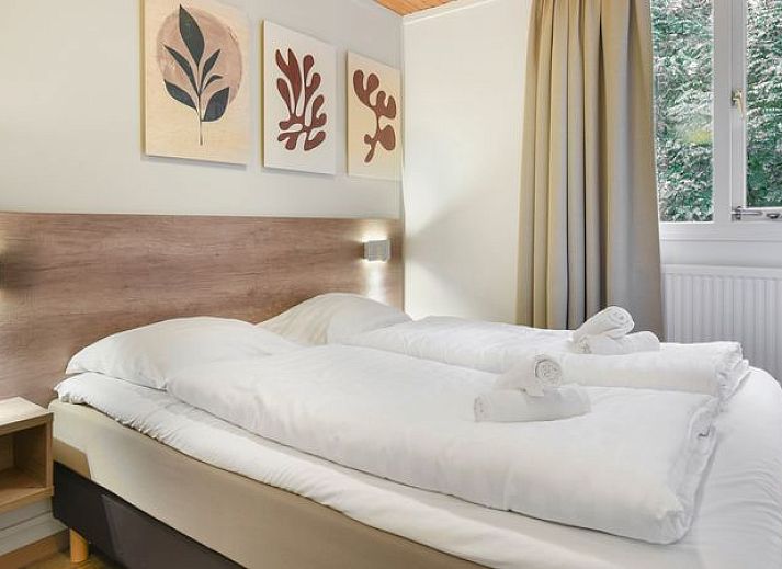 Gezellige woonkamer van Coldenhove 6-persoons bungalow 6C in Eerbeek, Veluwe met uitzicht op groen.