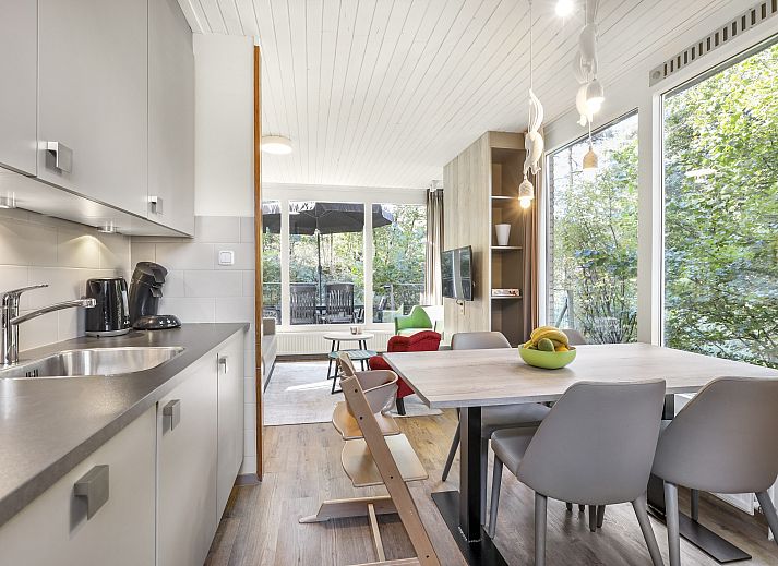 Geraeumiges Wohnzimmer des 4-Bett-Babybungalows Coldenhove in Eerbeek, Veluwe, mit gemuetlicher Sitzecke und Essbereich.