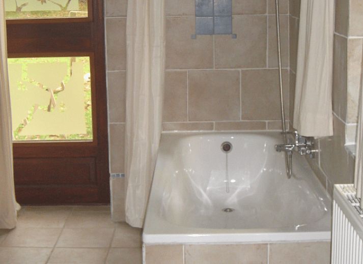 Cozy dining room in Holiday Home in Wenum Wiesel, Veluwe, with wooden table and chairs.