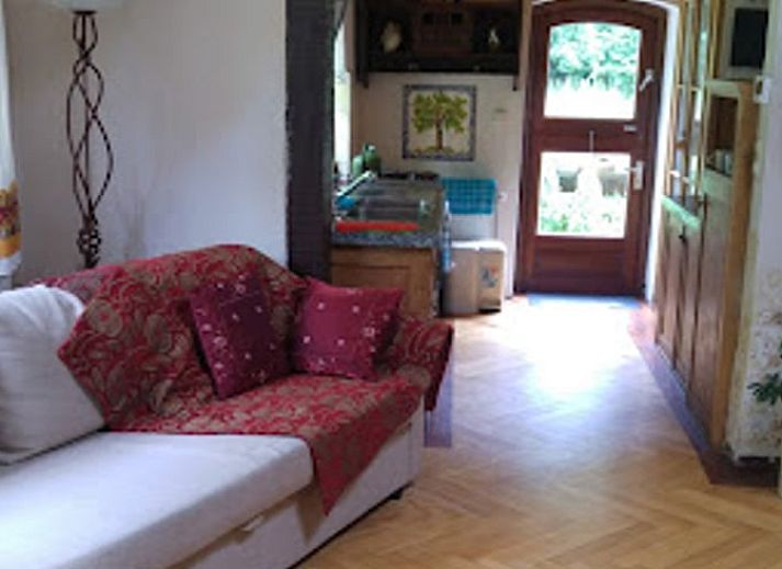 Cozy sitting area in Holiday Home in Wenum Wiesel, Veluwe, with sofa and wood stove.