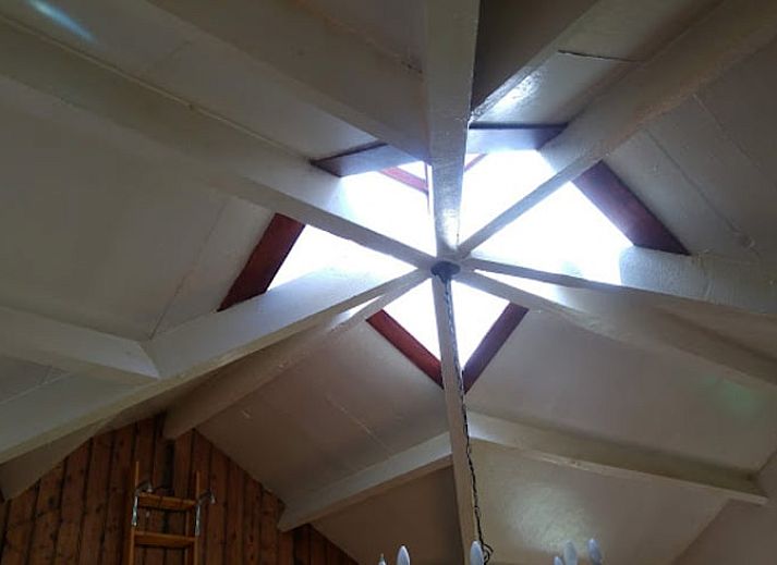 Cozy sitting area in Holiday Home in Wenum Wiesel, Veluwe, with sofa and wood stove.