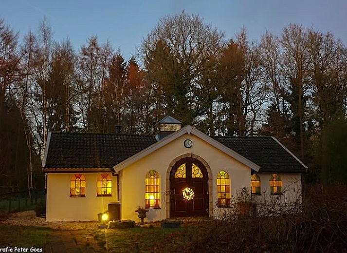 Cozy sitting area in Holiday Home in Wenum Wiesel, Veluwe, with sofa and wood stove.