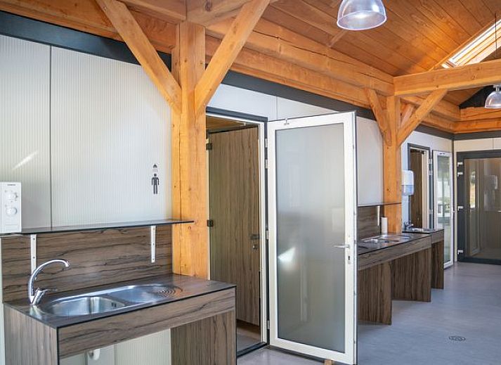 Comfort campingplaats C16 op Rabbit Hill, Nieuw Milligen, Veluwe, Gelderland met stacaravan en bomen.