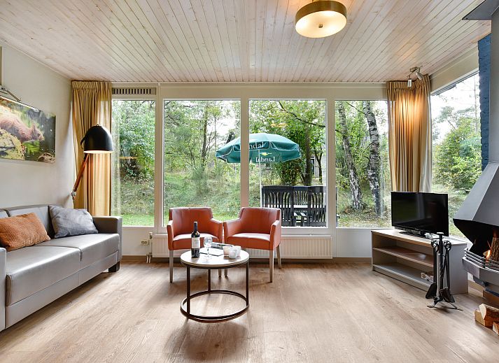 Woonkamer van Rabbit Hill bungalow in Nieuw Milligen met uitzicht op de natuur.