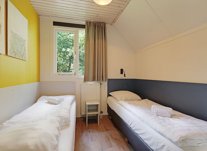 Gezellige woonkamer in Rabbit Hill 8-persoons bungalow 8C, Nieuw Milligen, Veluwe, met comfortabele zithoek en houten interieur.