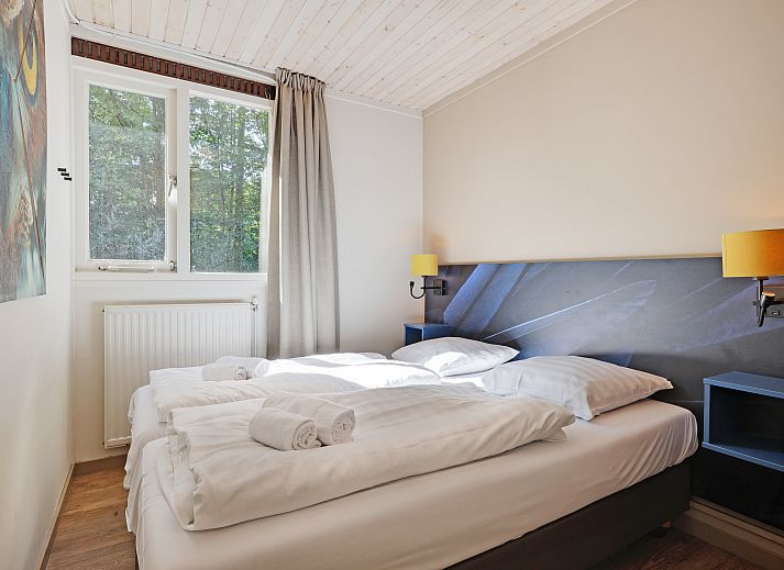 Gezellige woonkamer in Rabbit Hill 8-persoons bungalow 8C, Nieuw Milligen, Veluwe, met comfortabele zithoek en houten interieur.