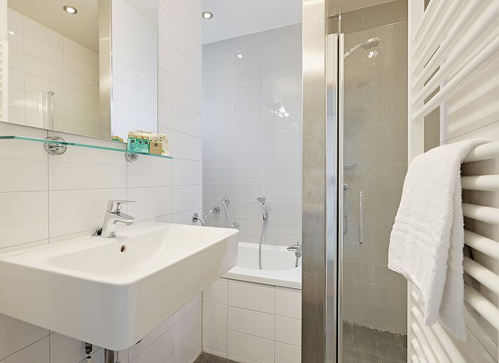 Gezellige woonkamer in Rabbit Hill 8-persoons bungalow 8C, Nieuw Milligen, Veluwe, met comfortabele zithoek en houten interieur.