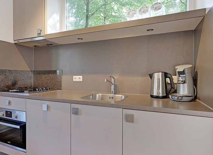 Gezellige woonkamer in Rabbit Hill 8-persoons bungalow 8C, Nieuw Milligen, Veluwe, met comfortabele zithoek en houten interieur.