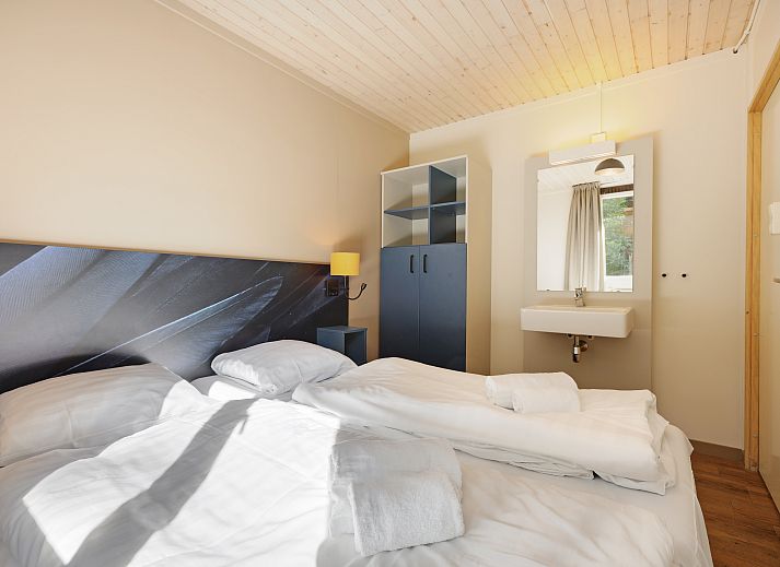 Lichte woonkamer van Rabbit Hill 8-persoons bungalow 8C in Nieuw Milligen, Veluwe, met grote ramen en uitzicht op de natuur.