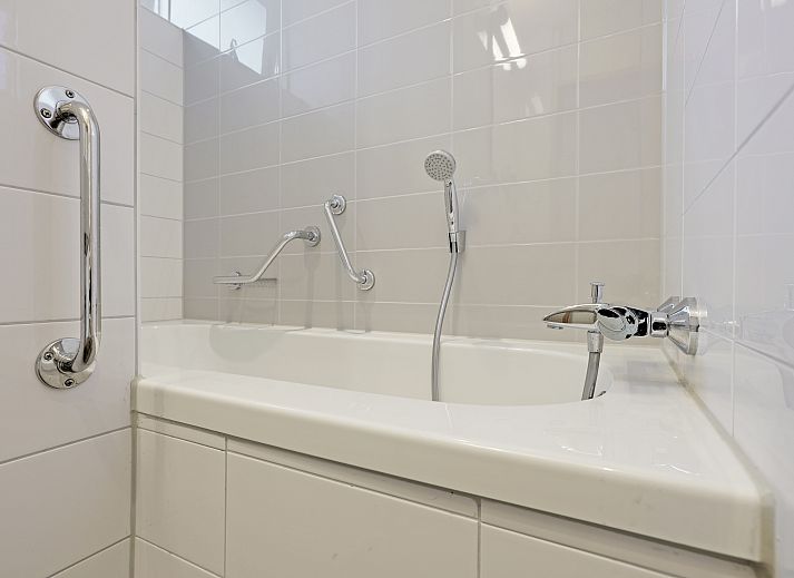 Lichte woonkamer van Rabbit Hill 8-persoons bungalow 8C in Nieuw Milligen, Veluwe, met grote ramen en uitzicht op de natuur.