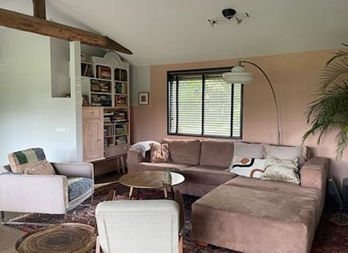 Gemuetliches Wohnzimmer im Ferienhaus in Nijkerk, Veluwe, mit rustikalen Moebeln.