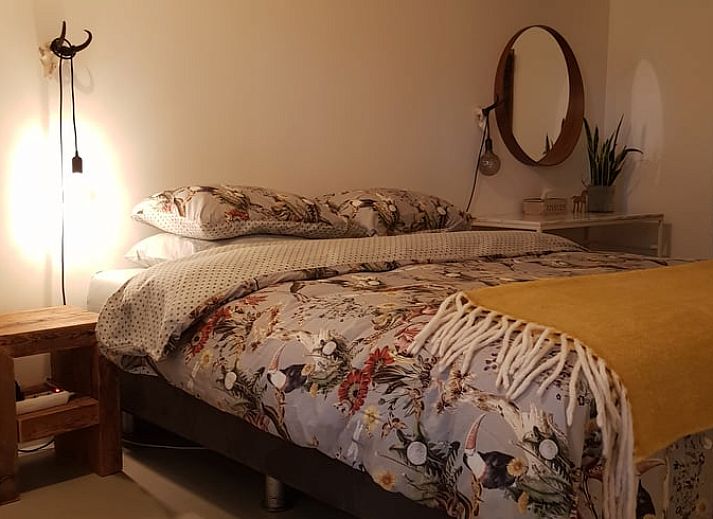 Lichte woonkamer met uitzicht op tuin in Vakantiehuisje in Nijkerk, Veluwe, Gelderland.