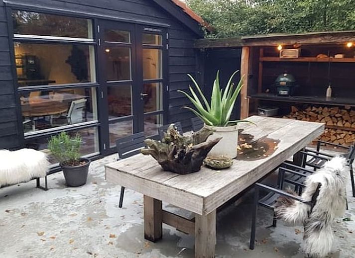 Lichte woonkamer met uitzicht op tuin in Vakantiehuisje in Nijkerk, Veluwe, Gelderland.