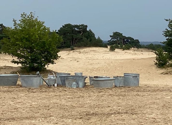 Zonnige serre van Vakantiehuisje in Kootwijkerbroek, Veluwe, met uitzicht op de tuin en comfortabele stoelen.