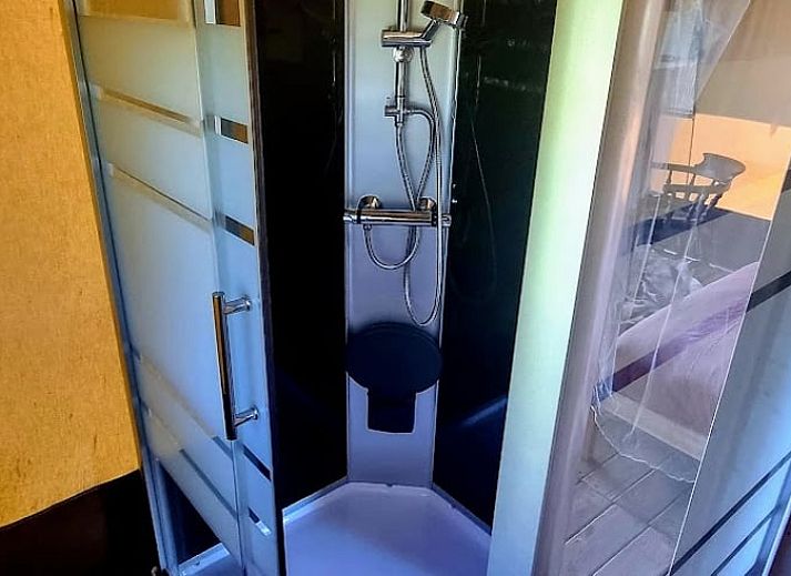 Veranda van het Vakantiehuis in Klarenbeek, een tenthuis op de Veluwe, met comfortabele stoelen.