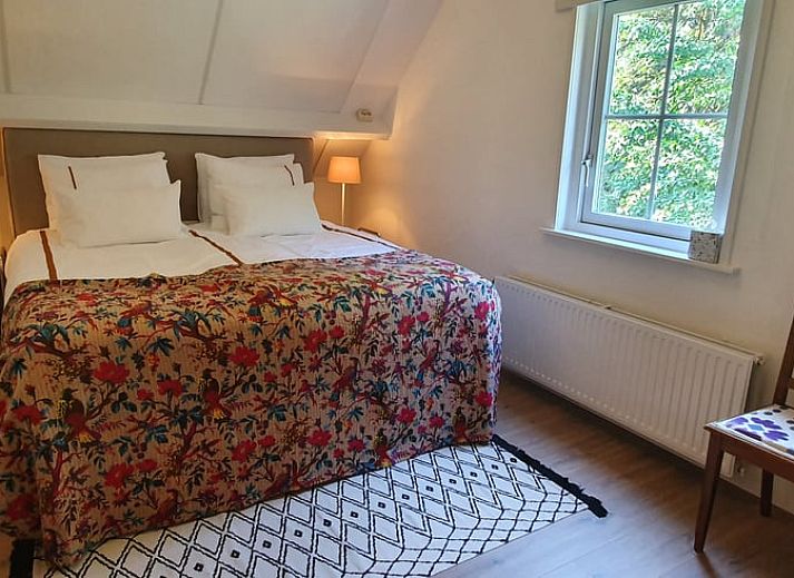 Charmant vakantiehuis Huisje in Klarenbeek omringd door kleurrijke bloemen in Veluwe, Gelderland.